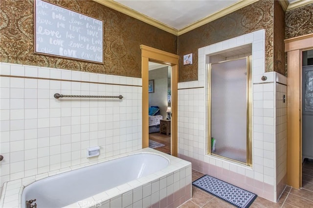ensuite bathroom with tile walls, crown molding, a shower stall, tile patterned flooring, and a garden tub