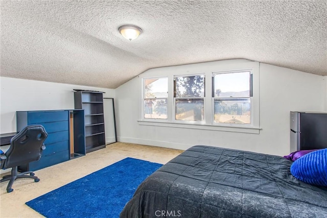 carpeted bedroom featuring a textured ceiling, freestanding refrigerator, baseboards, and lofted ceiling