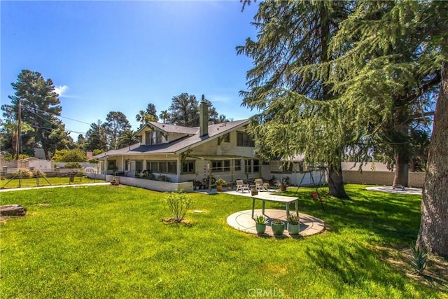 back of property with a patio, a sunroom, a yard, and fence