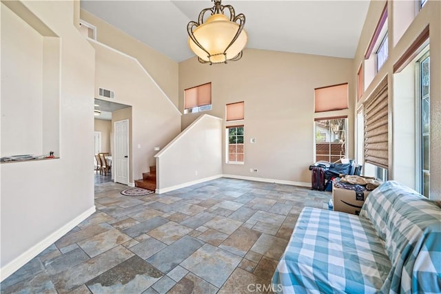 1010 W Wilson St, Pomona, CA 91768 - foyer featuring stone tile flooring, visible vents, baseboards, stairway, and high vaulted ceiling