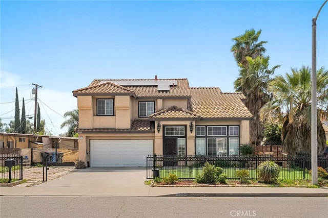 1010 W Wilson St, Pomona, CA 91768 - mediterranean / spanish-style house featuring a fenced front yard, driveway, a tiled roof, stucco siding, and solar panels
