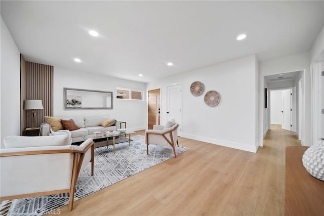 living area with recessed lighting, baseboards, and light wood finished floors