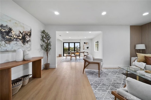 living room with recessed lighting, baseboards, and light wood-style flooring