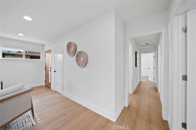 corridor with recessed lighting, baseboards, and light wood-style floors