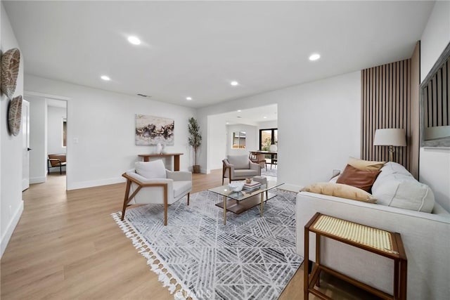 living room with recessed lighting, baseboards, light wood finished floors, and visible vents