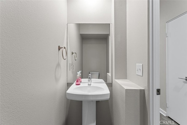 half bathroom featuring a textured wall