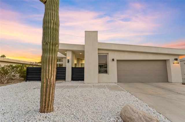 view of front of property featuring concrete driveway, stucco siding, and an attached garage