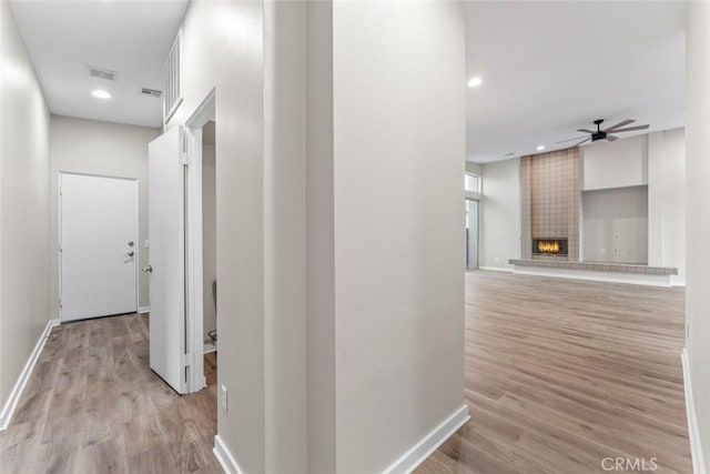 corridor with visible vents, baseboards, recessed lighting, and light wood-style floors