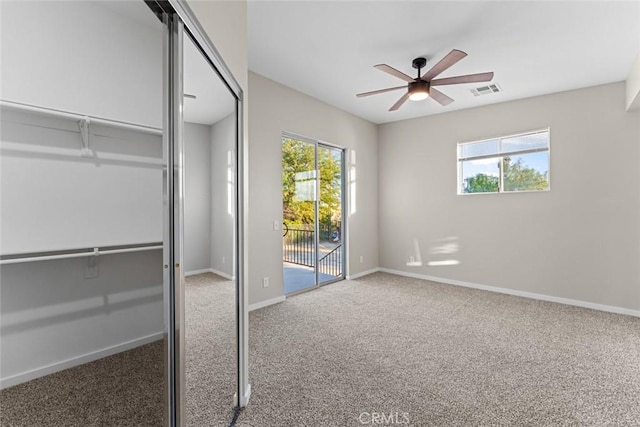 unfurnished bedroom with visible vents, access to exterior, multiple windows, and carpet