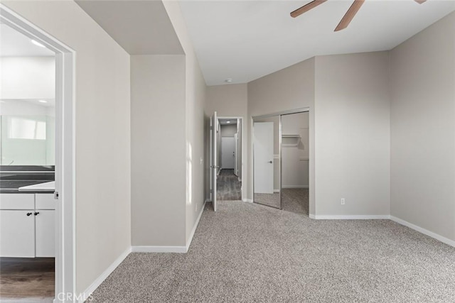 unfurnished bedroom with a closet, carpet flooring, ensuite bathroom, and baseboards