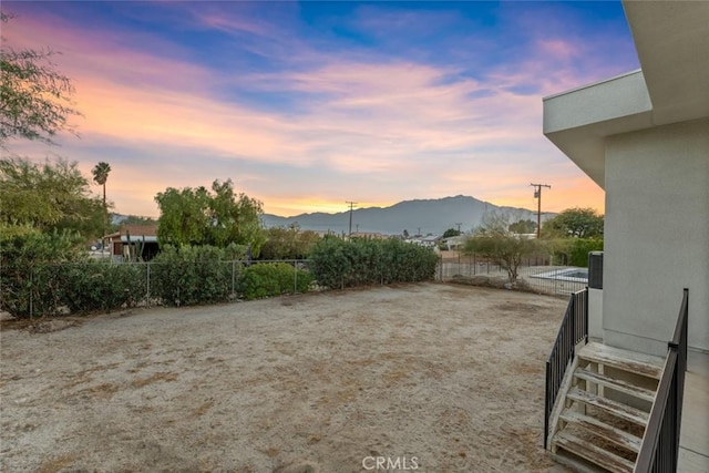 view of yard featuring a mountain view and fence