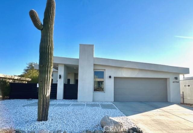 contemporary home featuring concrete driveway, stucco siding, and an attached garage