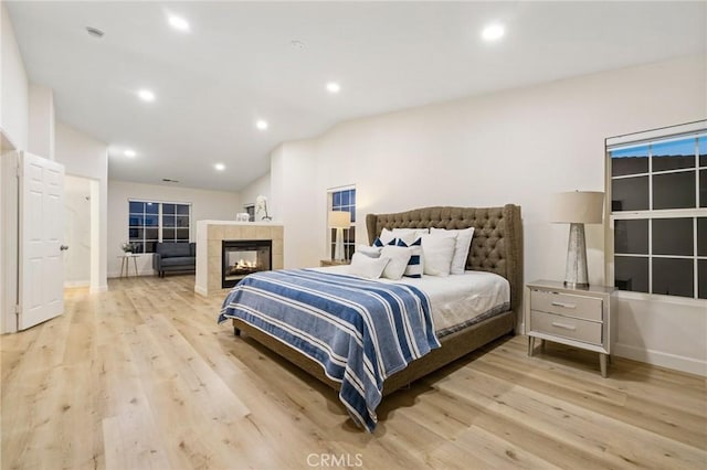12949 Colonial Dr, Rancho Cucamonga, CA 91739 - bedroom featuring baseboards, vaulted ceiling, recessed lighting, light wood-style floors, and a tile fireplace