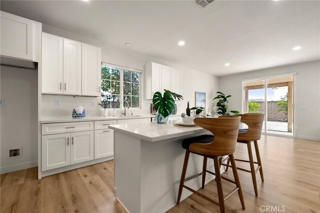 12949 Colonial Dr, Rancho Cucamonga, CA 91739 - kitchen with a sink, a center island, white cabinetry, and a healthy amount of sunlight