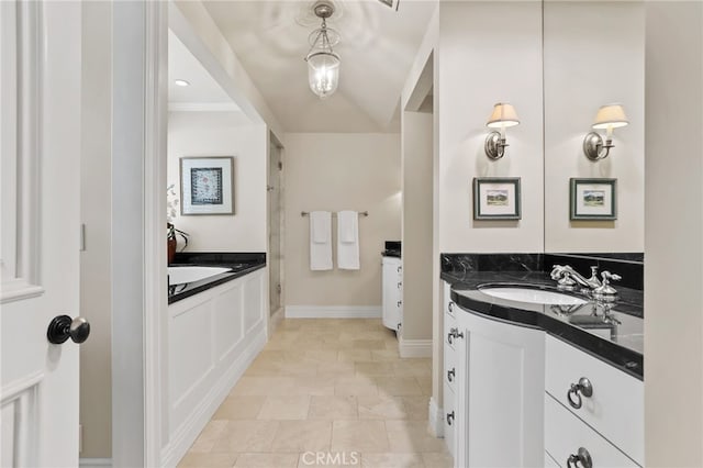 bathroom with a bath, vanity, baseboards, and walk in shower