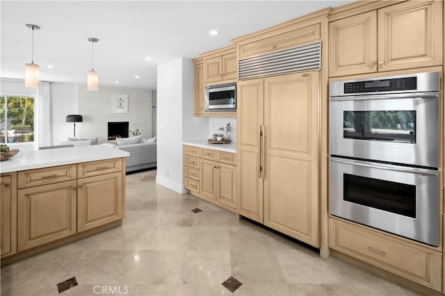 66 Drakes Bay Dr, Corona Del Mar, CA 92625 - kitchen with built in appliances, a large fireplace, light brown cabinets, decorative light fixtures, and light countertops