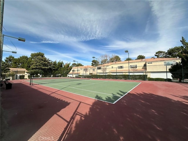 view of tennis court with fence and community basketball court
