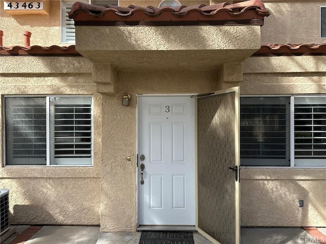 view of exterior entry featuring stucco siding