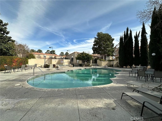 community pool featuring a patio and fence