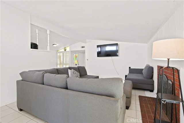 living area featuring tile patterned floors, visible vents, and lofted ceiling