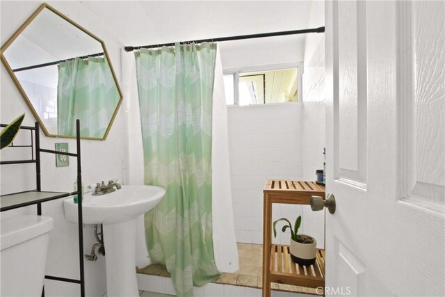 full bathroom featuring toilet and curtained shower