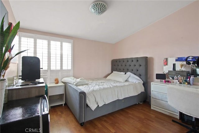bedroom featuring wood finished floors and vaulted ceiling