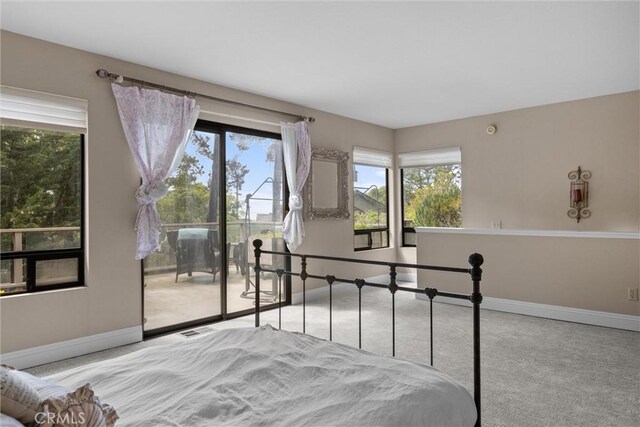 bedroom featuring access to exterior, visible vents, multiple windows, and baseboards