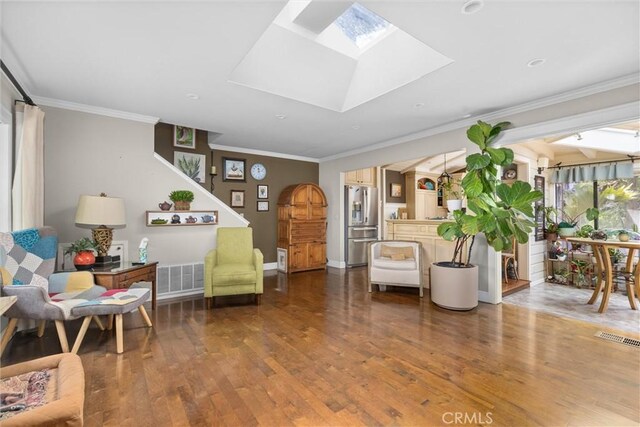 sitting room with visible vents, wood finished floors, a skylight, and crown molding