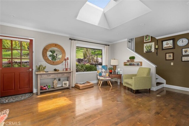 sitting room featuring wood finished floors, crown molding, baseboards, and a skylight