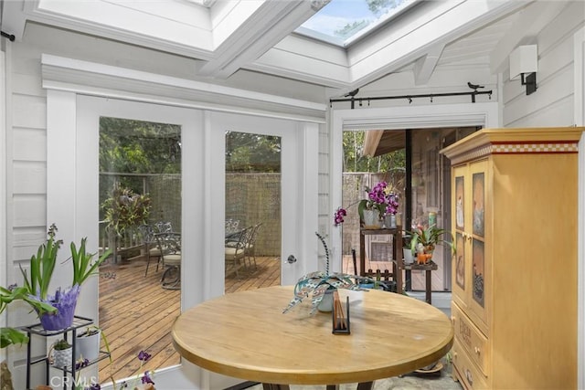 sunroom / solarium with beamed ceiling and a skylight