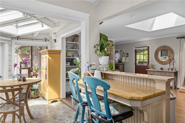 interior space with ornamental molding and a skylight