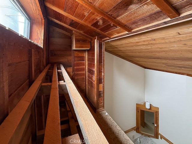 interior space featuring wood walls, an upstairs landing, lofted ceiling, and wood ceiling