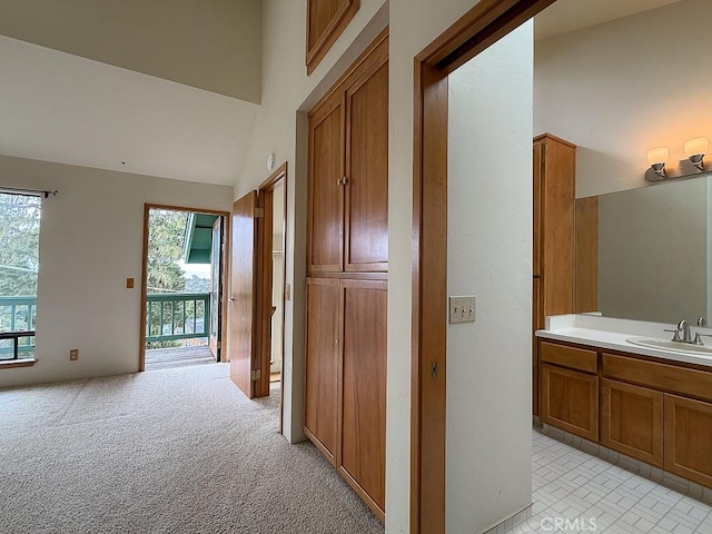 corridor with a sink and light colored carpet