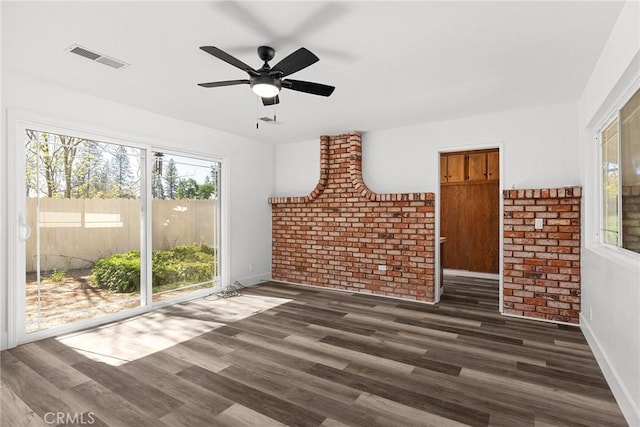 interior space with visible vents, a ceiling fan, dark wood-style flooring, and a healthy amount of sunlight
