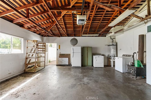 garage featuring freestanding refrigerator, washer and dryer, and strapped water heater