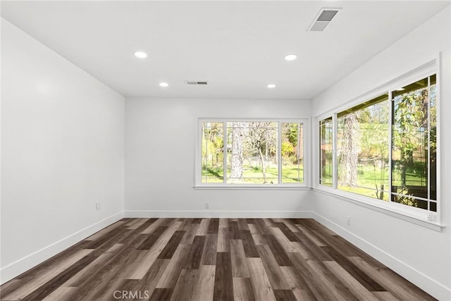 unfurnished room with baseboards, visible vents, recessed lighting, and dark wood finished floors