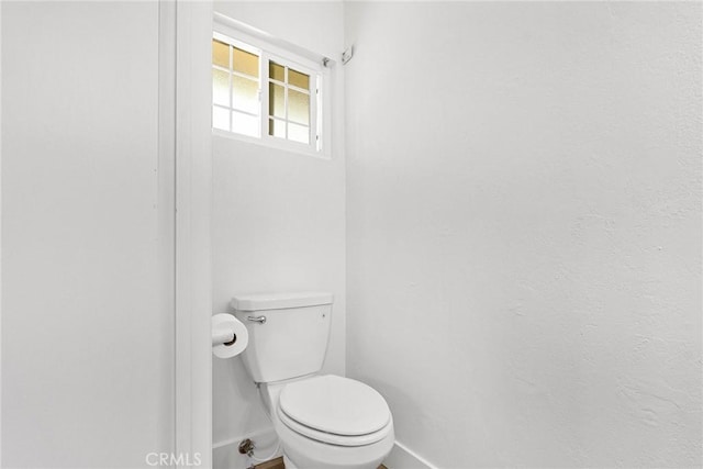 bathroom with baseboards and toilet