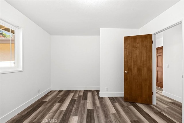 empty room featuring baseboards and wood finished floors