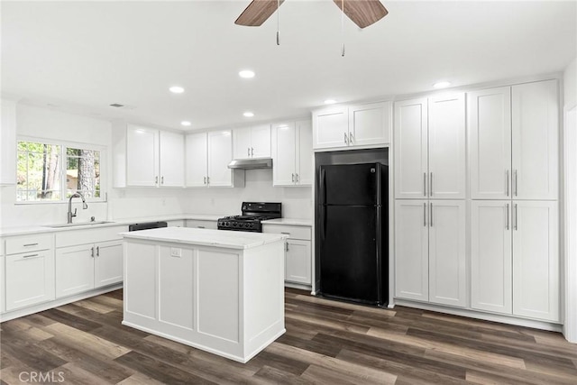 kitchen featuring recessed lighting, light countertops, a sink, and black appliances