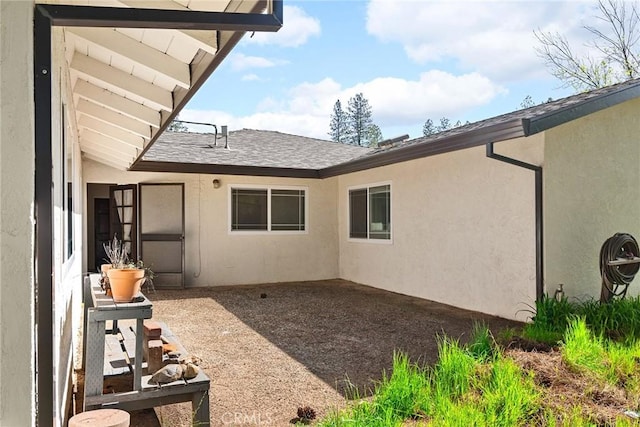 view of property exterior featuring stucco siding and roof with shingles
