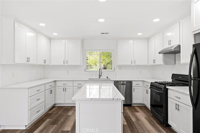 kitchen with a sink, under cabinet range hood, a kitchen island, dark wood-type flooring, and black appliances