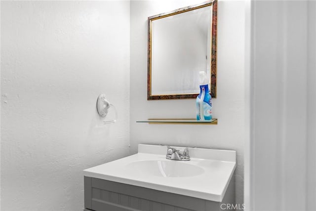 bathroom featuring a textured wall and vanity
