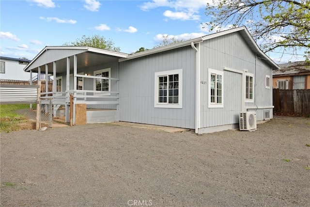 view of front of home featuring ac unit and fence