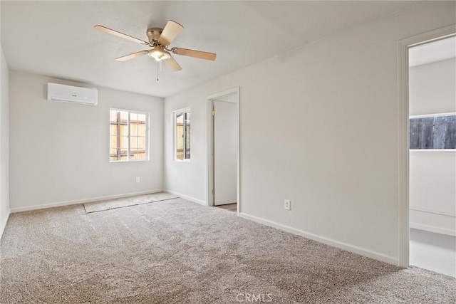 unfurnished room featuring carpet flooring, an AC wall unit, baseboards, and ceiling fan