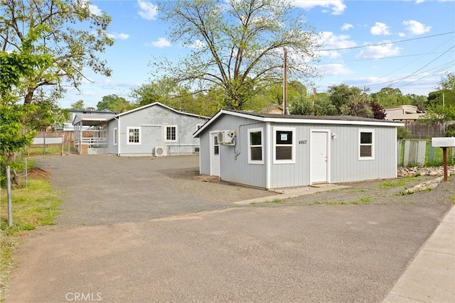view of front of home featuring an outbuilding and fence