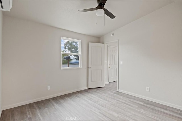 spare room featuring ceiling fan, baseboards, and wood finished floors