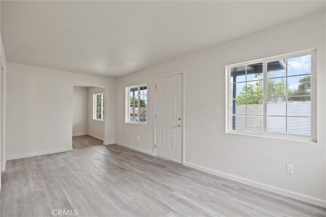 foyer entrance with light wood-style floors and baseboards