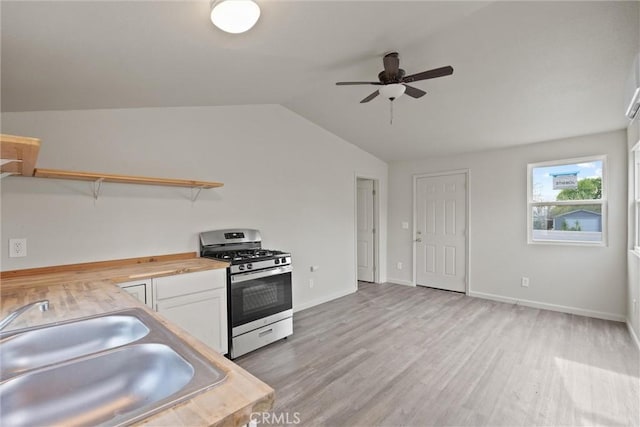 kitchen featuring butcher block counters, a ceiling fan, open shelves, vaulted ceiling, and gas range