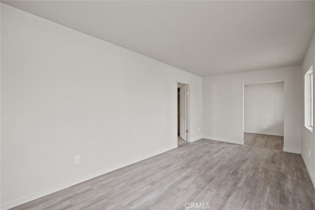 unfurnished room with baseboards and wood finished floors