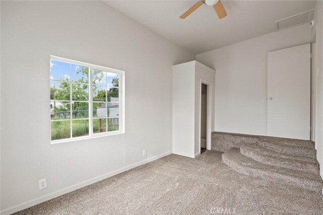 empty room featuring carpet flooring, baseboards, and a ceiling fan
